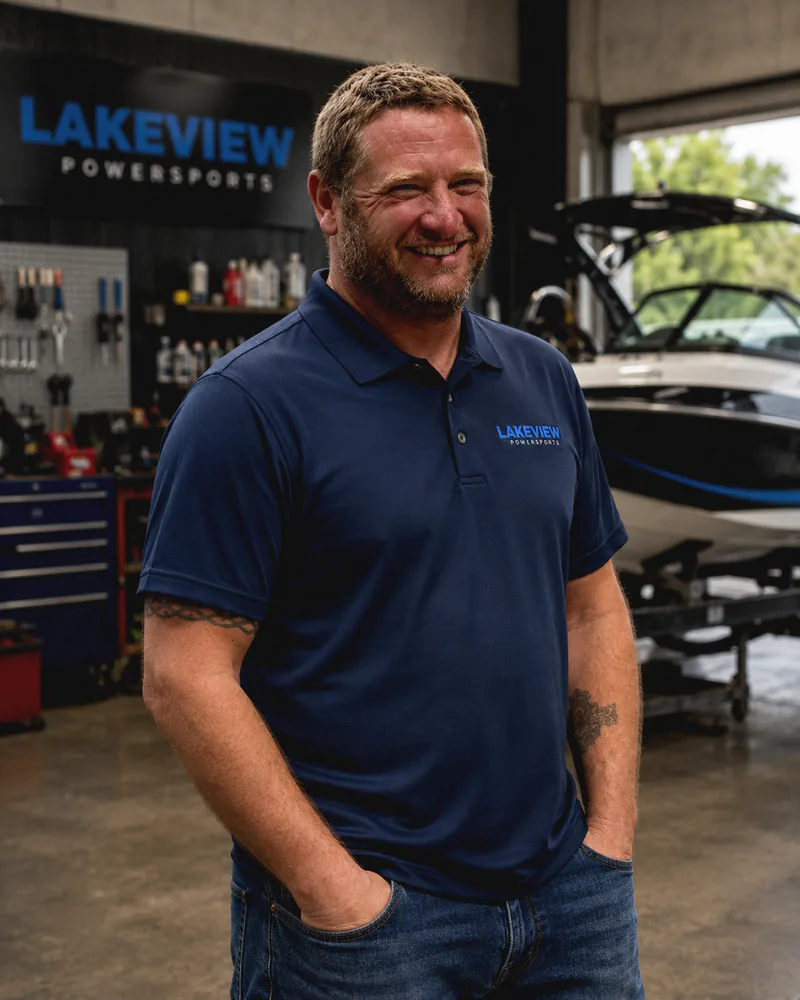 George, licensed mechanic at Lakeview Power Sports, in the workshop beside a boat on the trailer
