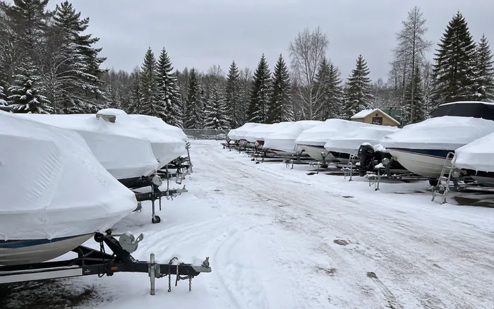 Rows of wrapped boats stored outdoors through winter at Lakeview Power Sports