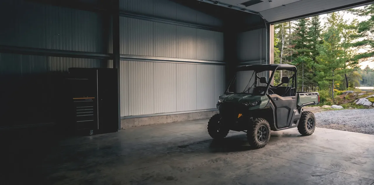 A side-by-side parked in the open bay door of the Lakeview Power Sports workshop